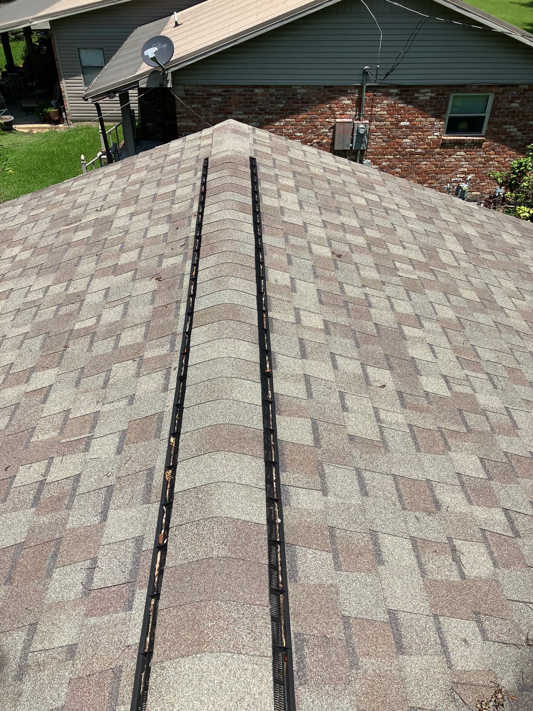 Roof view showing shingle pattern and gutter system, highlighting maintenance needs.